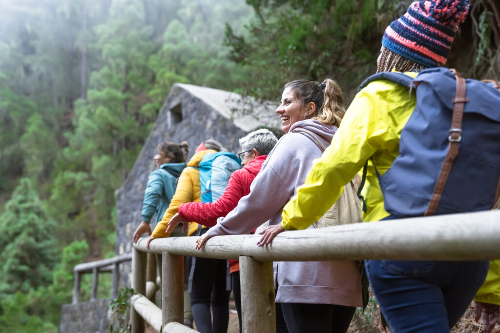 Group of women with different ages and ethnicities having fun walking in the woods enjoying cool weather activities