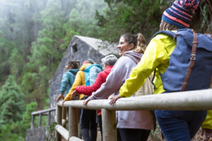 Group of women with different ages and ethnicities having fun walking in the woods enjoying cool weather activities