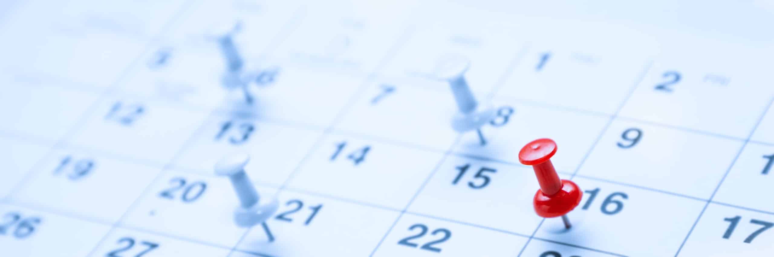 Paper desk calendar with thumbtacks, a red thumbtack indicating birthday in which the birthday rule applies