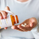 Sick woman taking medicine from prescription bottle. Prescription drugs are covered under Medicare Part D, that's why it's important to know your medications in choosing a Medicare Part D plan.