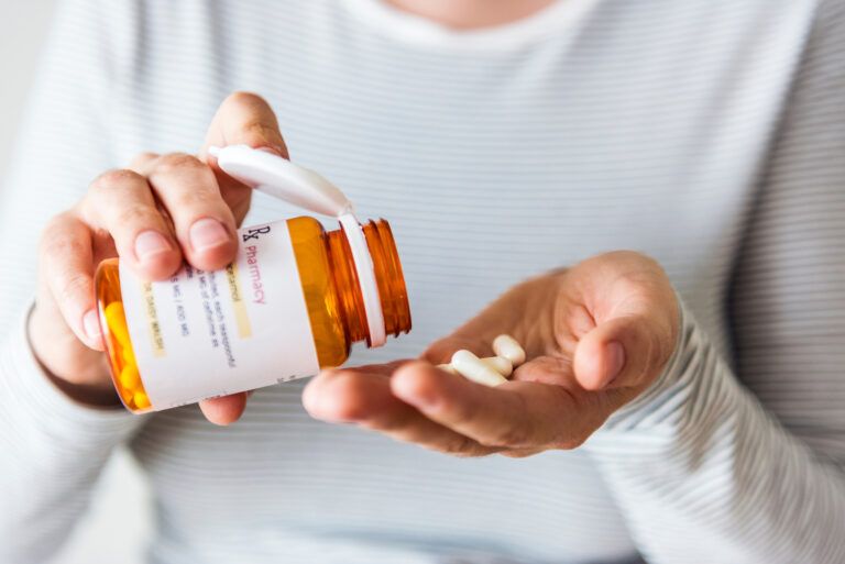 Sick woman taking medicine from prescription bottle. Prescription drugs are covered under Medicare Part D, that's why it's important to know your medications in choosing a Medicare Part D plan.