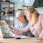 Senior woman using laptop for researching Medigap Part G with her daughter