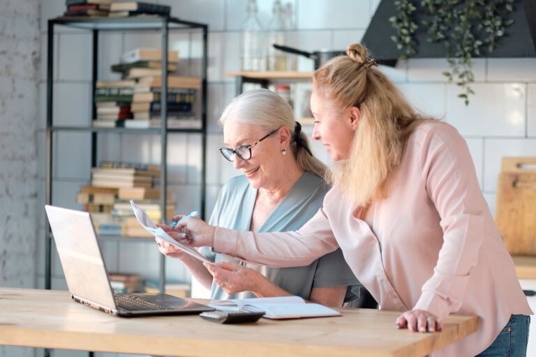 Senior woman using laptop for researching Medigap Part G with her daughter