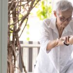 Caregiver holding hands of an elderly person for support, caregiver resources and support