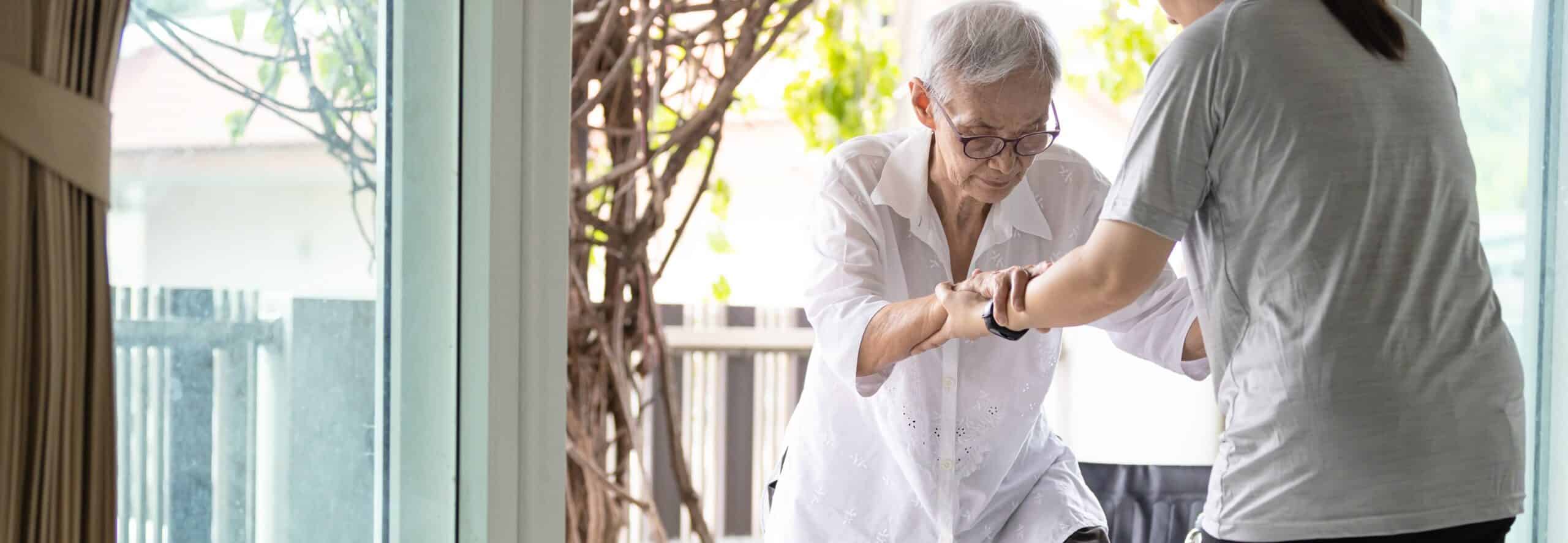 Caregiver holding hands of an elderly person for support, caregiver resources and support