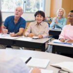 Mature students learning a new language with an instructor in a classroom