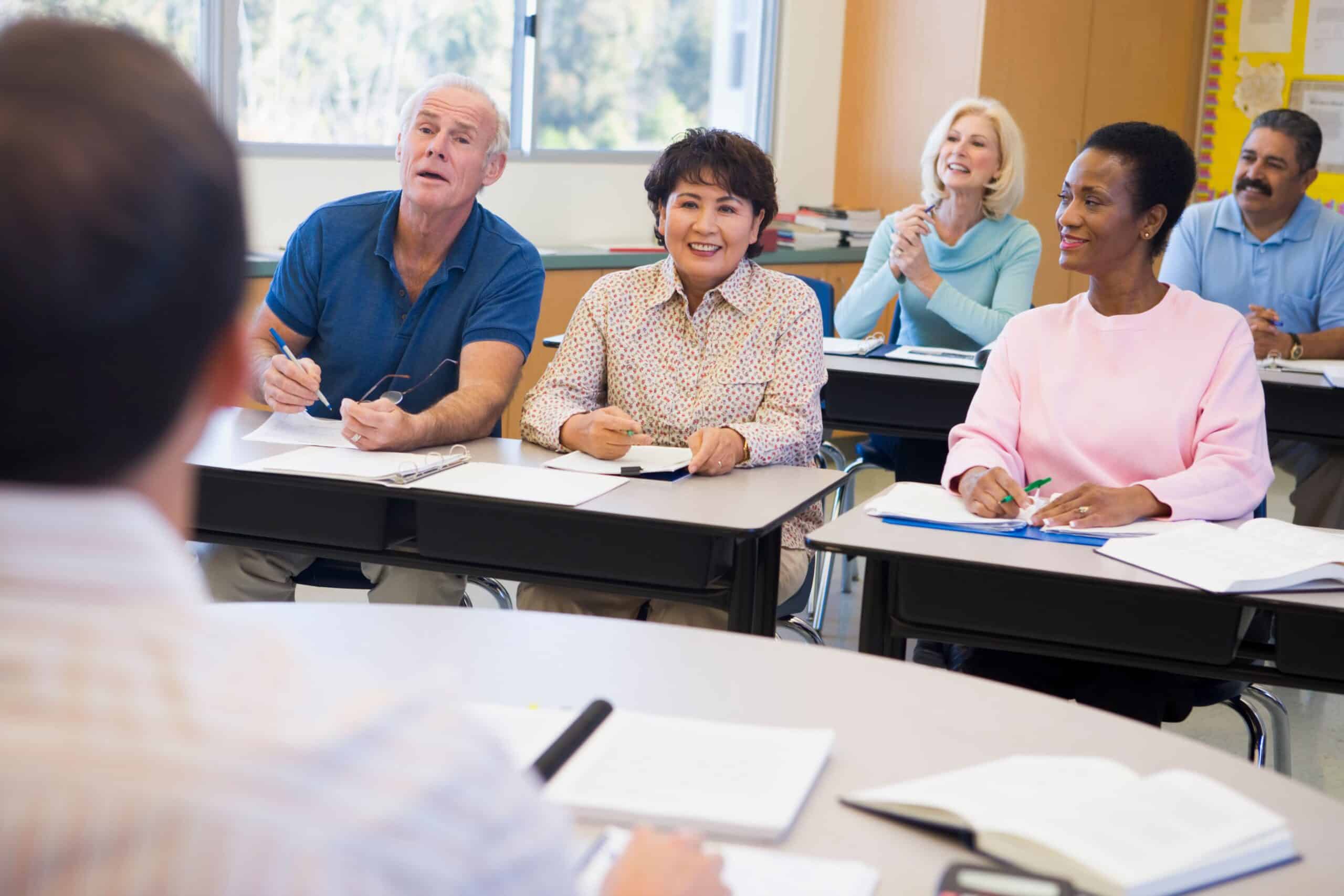 Mature students learning a new language with an instructor in a classroom