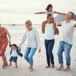 Happy big multi-generational family vacation on the beach, with parents, kids and grandparents.
