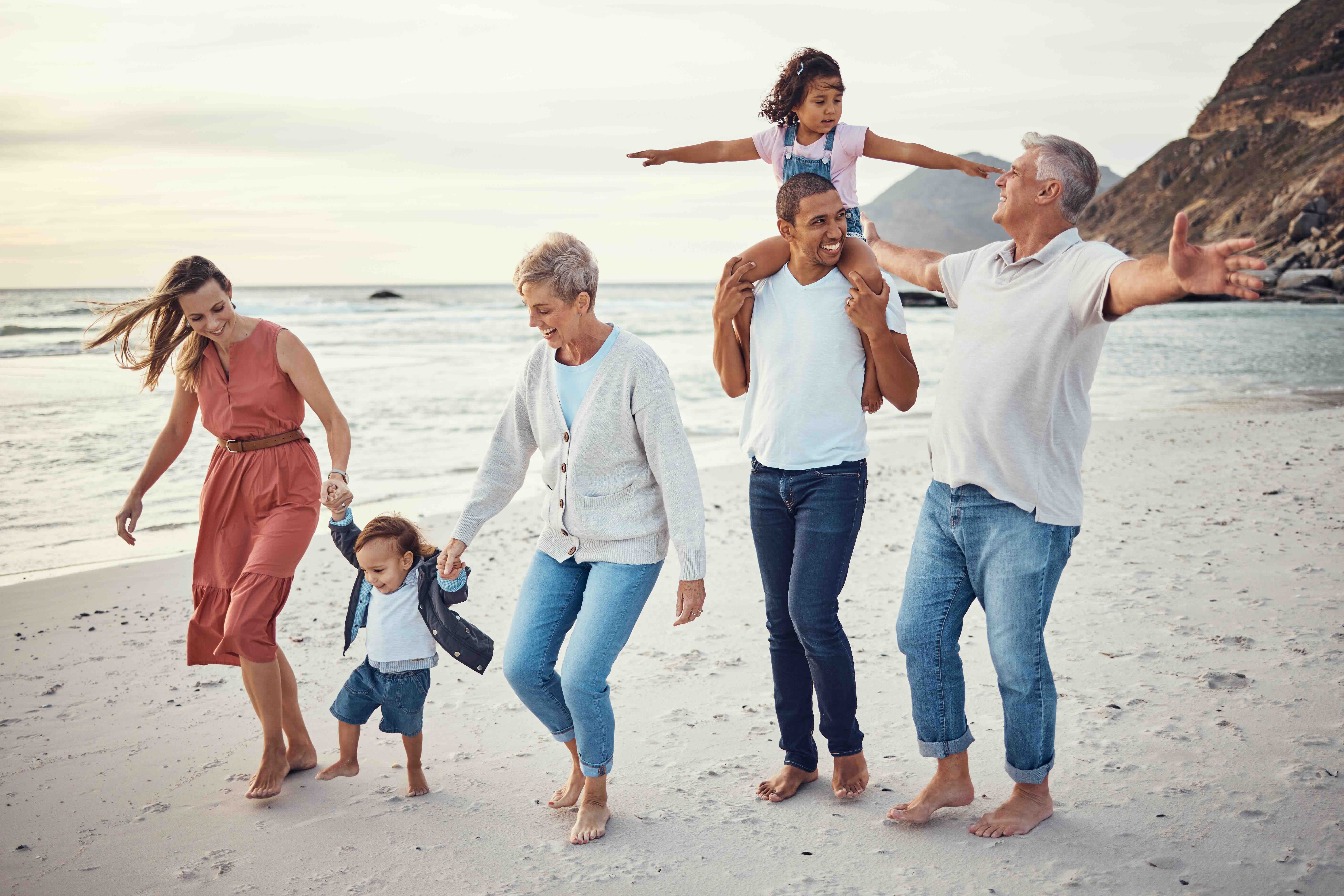 Happy big multi-generational family vacation on the beach, with parents, kids and grandparents.