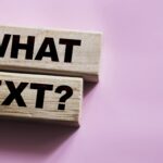 The words What Next on wooden blocks, close up shot, view from above. Next steps concept for business or Medicare changes