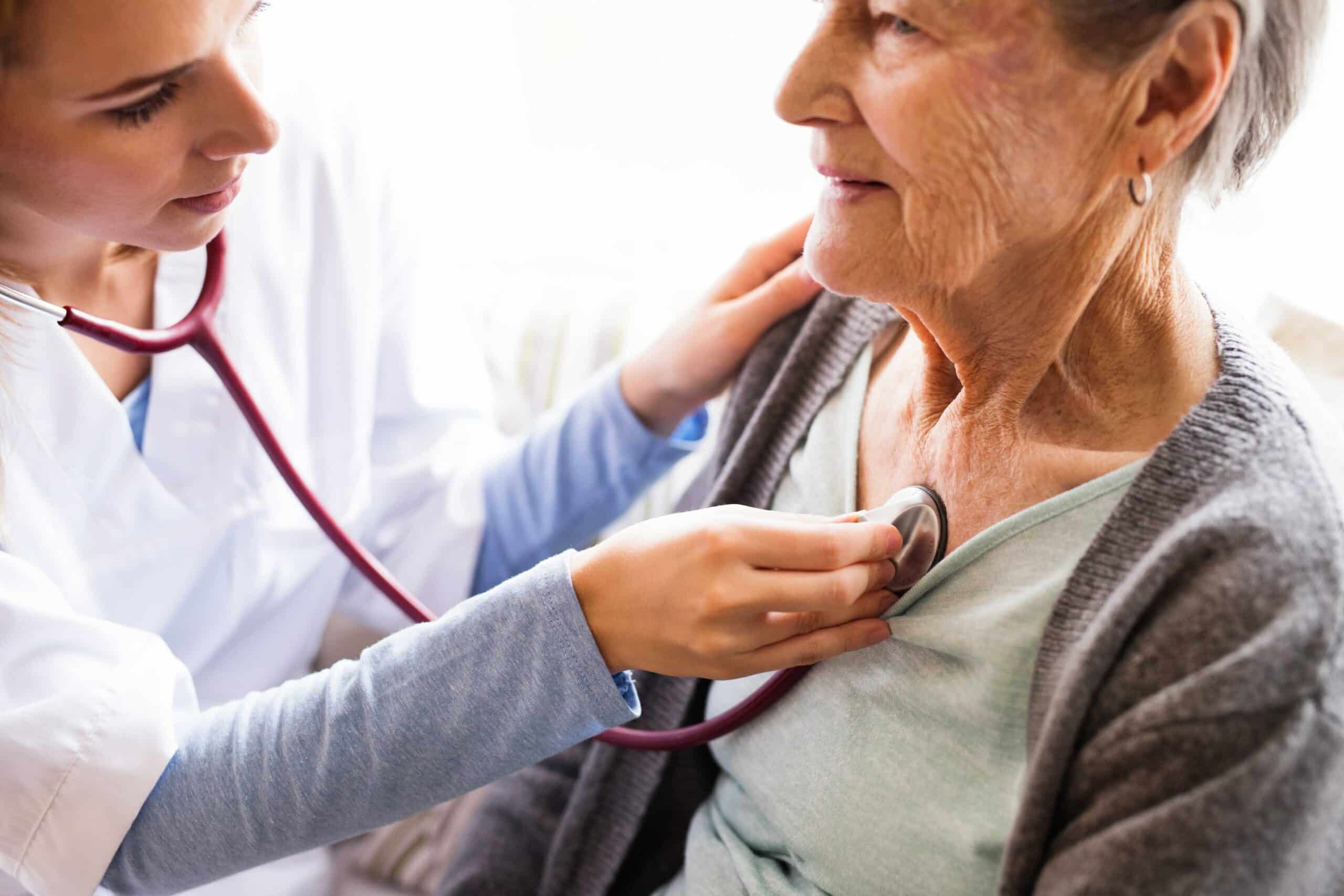 Health visitor and a senior woman during home visit. A nurse or a doctor examining a woman. Close up as a concept of coverage for Medicare Supplement preventive care.